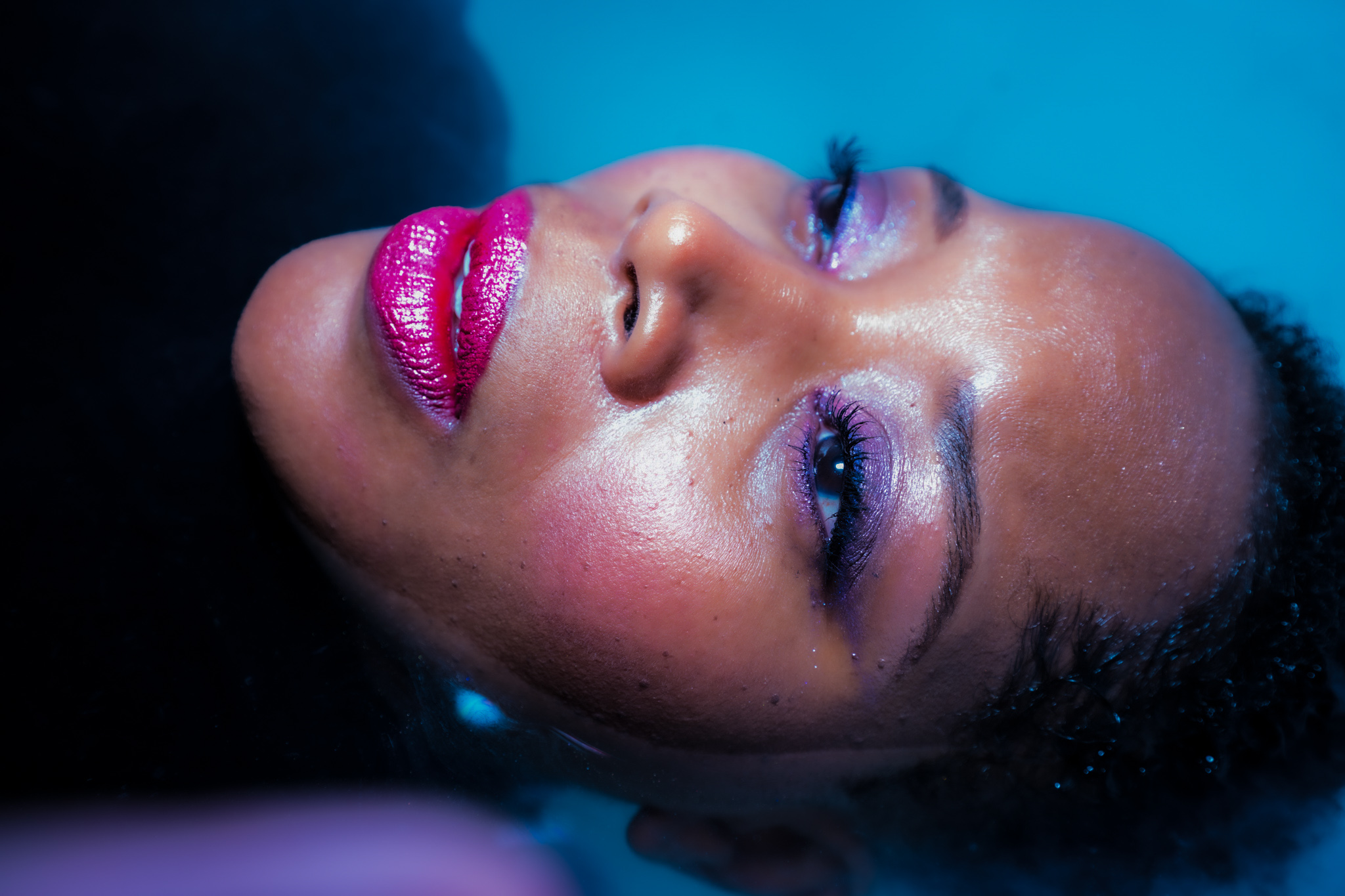 Beauty portrait with bold pink lip and blue-toned light