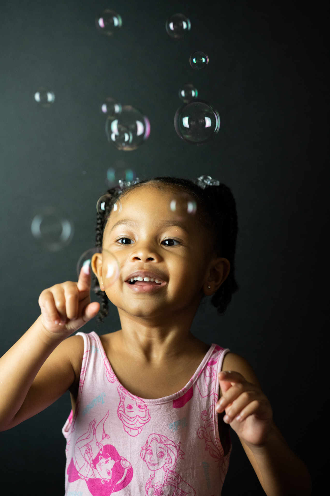 Child smiling while playing with bubbles